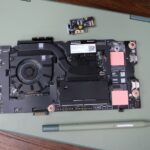 Framework Laptop 12 on a table, on top of which is the new mainboard, fingerprint reader and stylus.