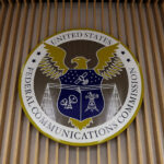 Photo of the Federal Communications Commission's insignia on the wall of the agency's briefing room.