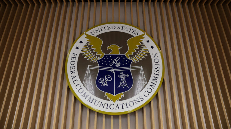 Photo of the Federal Communications Commission's insignia on the wall of the agency's briefing room.